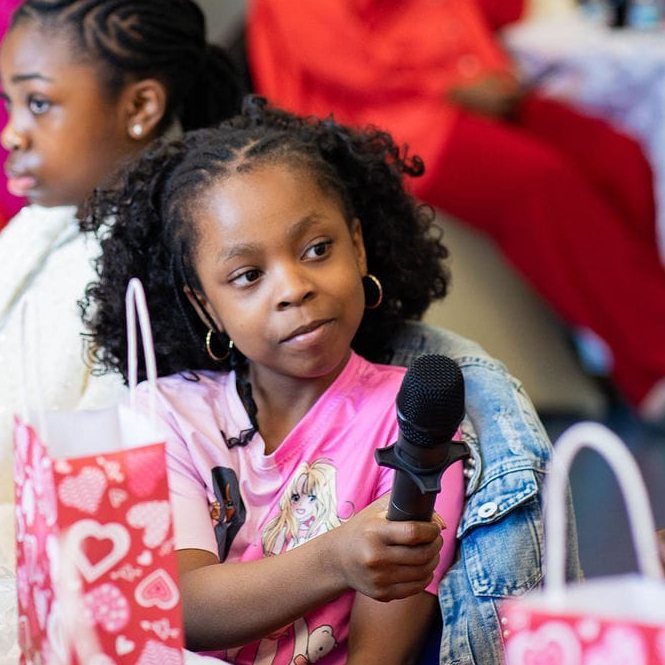 A young girl holding a microphone during a Responsible Girls Forum workshop